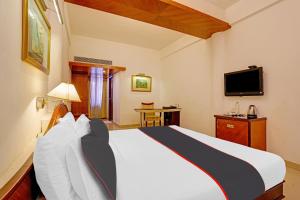 Hotel Indraprastha tesisinde bir odada yatak veya yataklar