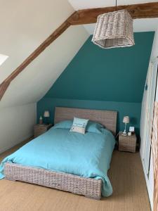 1 dormitorio con 1 cama con pared azul en La Métairie, en Domloup