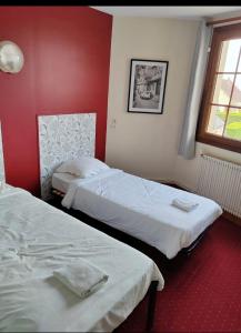 contact hôtel Le Temps Perdu في Le Bois de Cise: سريرين في غرفة بجدران حمراء