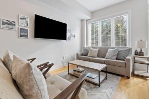 a living room with a couch and a tv at Mountain View Townhouse Fresh and Bright at Blue in Collingwood