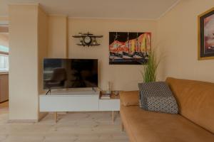 a living room with a couch and a flat screen tv at Cozy Cottage / 3BR / Hiking / Nature in Við Gjógv