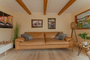 a living room with a brown leather couch at Cozy Cottage / 3BR / Hiking / Nature in Við Gjógv
