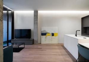 カタロハにあるCosy Loft's Valenciaの白いキャビネットと薄型テレビ付きのキッチンが備わります。