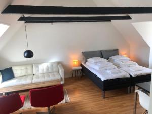 uma sala de estar com duas camas e um sofá em Huset ved springvandet em Randers