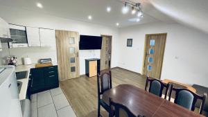 een keuken en een eetkamer met een tafel en een keuken gmaxwell gmaxwell gmaxwell gmaxwell gmaxwell bij Apartament Pod Kasztanami - BIAŁY in Ińsko +26 foto's