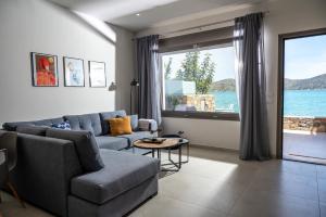 a living room with a couch and a large window at Blue Cove Zen in Elounda