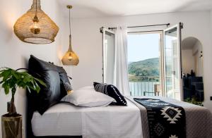 阿尔戈斯托利翁A & B Minimal Suite ΙΙ with Sea View in Argostoli的卧室里有一张床，配有黑白枕头