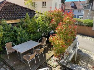 a wooden table and chairs in a garden with flowers at TTP 15 Markdorf in Markdorf