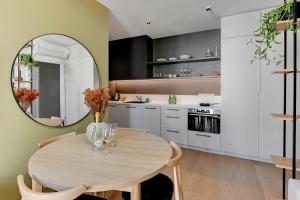 a kitchen with a wooden table and a mirror at Boutique Aura 40 by Grand Apartments in Gdańsk