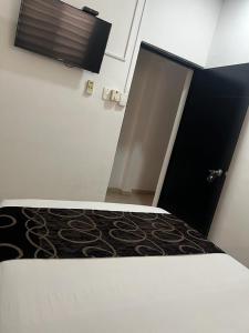 a room with a bed and an open door at Apartahotel y Hotel Sofichic Boutique in Barranquilla