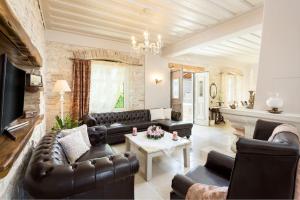 Una sala de estar con sofás de cuero y una mesa. en La Maison, en Velianitátika