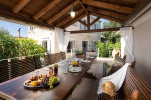 una mesa de madera con un bol de fruta en el patio en La Maison, en Velianitátika
