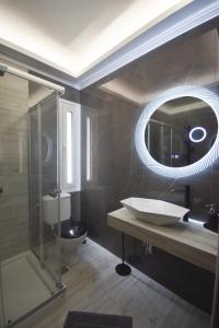 a bathroom with a sink and a mirror at K&C Rooms- Apartments in Markopoulo