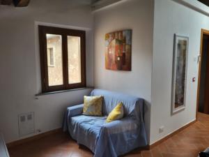 a living room with a blue couch and a window at Suite Bellavista con angolo cottura in Peccioli