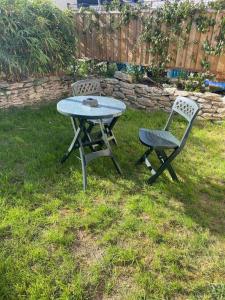 ゲランドにあるAppartement avec Jardinの庭のピクニックテーブルと椅子2脚