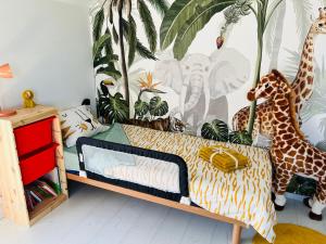 Maison familiale à Dinant في دينانت: غرفة نوم عليها سرير وزرافات