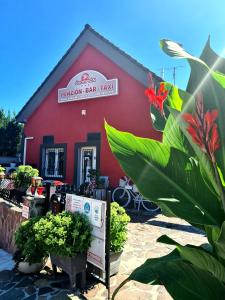 un edificio rojo con plantas delante de él en Penzion Škorpión, en Senec