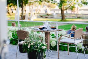 una mesa y sillas con comida y copas de vino. en Rannahotell en Pärnu