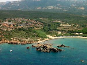 z powietrza widok na plażę z kamieniami w wodzie w obiekcie Calarossa Sardinia Apartments w mieście Isola Rossa
