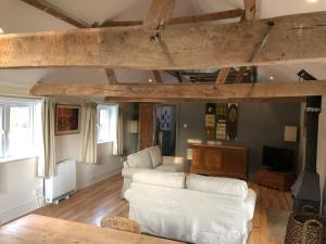 a living room with a white couch and a tv at The Cowshed in Salisbury