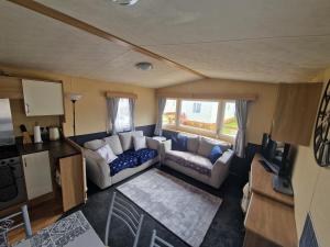 Sala de estar con sofá y mesa en Taylor's Highland Escape, Dornoch en Dornoch