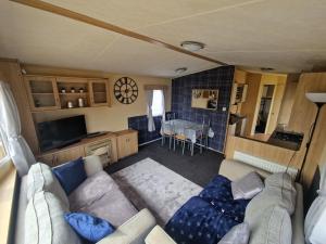 sala de estar con sofá y cocina en Taylor's Highland Escape, Dornoch en Dornoch