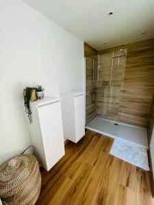 uma casa de banho com uma cabina de duche ao nível do chão e pisos em madeira em Maison familiale à Dinant em Dinant