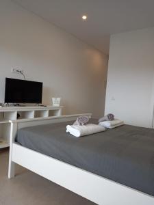 a white bedroom with a bed and a desk at Monte Papa Figos in Malhão