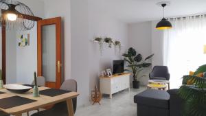 a living room with a couch and a table at Sherryflat Claveles - Parking in Jerez de la Frontera