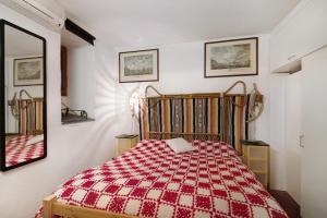 a bedroom with a bed with a red and white blanket at Alloggio di Charme in Bonassola