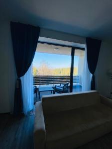 a living room with a couch and a large window at Silver Mountain C24 Royal in Poiana Brasov