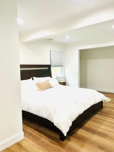 Schlafzimmer mit einem großen weißen Bett und Holzboden in der Unterkunft The Cottage at Glenwood Retreats 