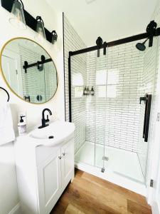 ein Bad mit einer Dusche, einem Waschbecken und einem Spiegel in der Unterkunft The Cottage at Glenwood Retreats 