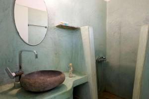 a bathroom with a stone sink and a mirror at Guardiero in Kithnos