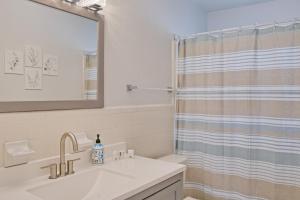 a bathroom with a sink and a shower curtain at Good Vibes - Serenity in Naples +13 photos