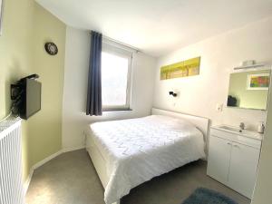 sypialnia z białym łóżkiem i oknem w obiekcie Au logement mosan w mieście Namur