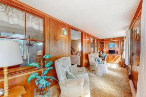 una sala de estar con paredes y sillas de madera y una mesa. en Irish Ayes Beach House, en Wareham