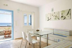 a dining room with a glass table and white chairs at Guardiero in Kithnos +44 photos