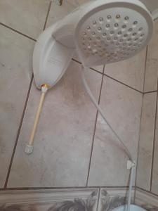 a bathroom floor with a shower head and a toilet at Suíte Azul com SmartTv, Cama Queen e Banheiro Privativo in Itajaí