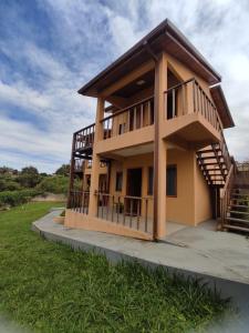 ein großes Haus mit einer Treppe auf einem Feld in der Unterkunft TEMPO FLATS E HOSPEDAGEM in Alto Paraíso de Goiás