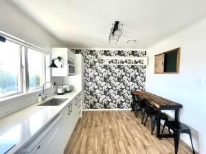 a kitchen with a sink and a wooden table at Alta House in Auckland