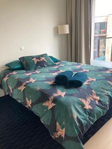 a bed with a colorful comforter with leaves on it at Cozy two bedroom Apartment near city centre Gent in Ghent
