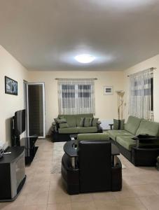 uma sala de estar com sofás e uma televisão de ecrã plano em Irish Apartment Becici em Budva