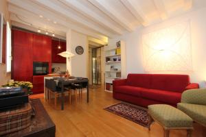 a living room with a red couch and a table at City Apartments Cannaregio in Venice