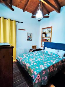 ein Schlafzimmer mit einem Bett mit einer grünen Bettdecke in der Unterkunft Archontiko Kastellia in Evangelístria