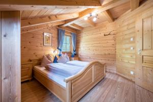 una camera da letto in una baita di tronchi con un letto in esso di Ferienhaus Pichlerhof a Fundres