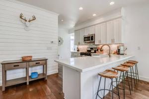 eine Küche mit weißen Schränken und einer großen Insel mit Hockern in der Unterkunft Beach Vibes in Lincoln City