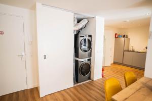 ein Wohnzimmer mit Waschmaschine und Trockner in einem Haus in der Unterkunft Happy 1 Bedroom Apartment in Tiel