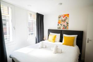 een slaapkamer met 2 witte bedden en gele kussens bij Happy 1 Bedroom Apartment in Tiel