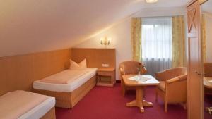 ein Hotelzimmer mit einem Bett und einem Schreibtisch in der Unterkunft Landhaus Seeblick in Füssen